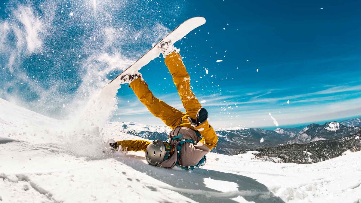 O niebezpieczeństwach na trasach narciarskich w programie „Pytanie na śniadanie”. Snowboardzista w kasku przewraca się na stoku, a w powietrzu widać rozbryzg śniegu i uniesioną deskę. W tle rozciąga się górski krajobraz oraz ośnieżone zbocza pod błękitnym niebem.